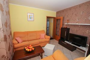 a living room with a couch and a tv at Apartmani Ljubica in Poreč