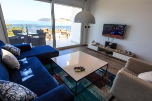 een woonkamer met een blauwe bank en een tafel bij Apartmani Capri in Sutomore