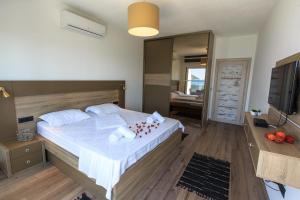 een slaapkamer met een groot bed met kussens erop bij Apartmani Capri in Sutomore