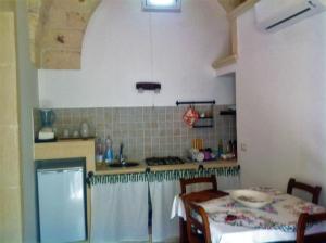 a small kitchen with a table and a stove at La Casetta in Poggiardo