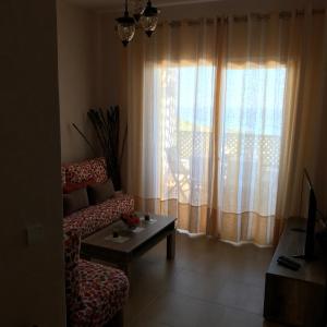 - un salon avec un canapé et une fenêtre dans l'établissement Appartement Bellavista - Cabo Negro, à Cabo Negro