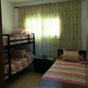 a bedroom with two bunk beds and a window at Appartement Bellavista - Cabo Negro in Cabo Negro