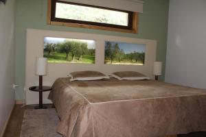 a bedroom with a large bed with two windows at Moinho da Ponte Velha in Bragança