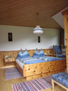 sypialnia z dużym drewnianym łóżkiem z niebieskimi poduszkami w obiekcie Kocherhof w mieście Mariapfarr