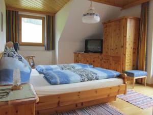 a bedroom with a large bed and a tv at Kocherhof in Mariapfarr