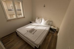 a bed in a small room with a window at Apartments Matanovi Dvori in Makarska +84 photos