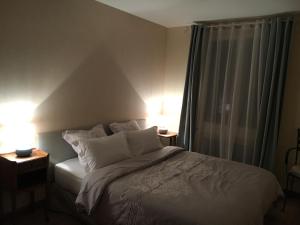1 dormitorio con 1 cama con 2 lámparas y una ventana en Holiday Home Castle View, en Pierrefonds