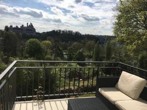 a balcony with a couch and a view of a castle at Holiday Home Castle View in Pierrefonds