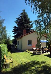 ein Haus mit einem Garten mit einem Tisch und Stühlen in der Unterkunft Ferienhaus zur Blautanne in Klipphausen