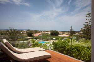 a deck with two lounge chairs and a swimming pool at Artemis Village Apartments & Studios in Stavros