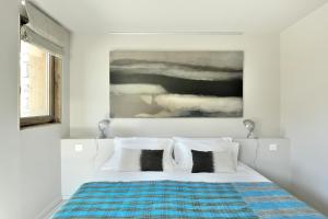 een slaapkamer met een bed met een schilderij aan de muur bij Home by U - Chalet 2 in Saint-Martin-de-Belleville
