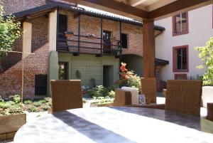 een patio met een tafel en stoelen voor een gebouw bij Studio Sforzesco in Bellinzago Novarese