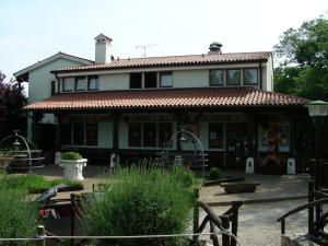 a large house with a tiled roof in a yard at Agriturismo Mezzaluna in Málchina