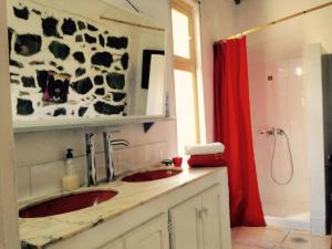 エルミグアにあるCasa Auraのバスルーム(シンク2台、赤いシャワーカーテン付)