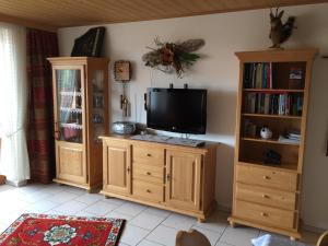 a living room with a tv on a wooden cabinet at Ferienwohnung Familie Zuck in Missen-Wilhams