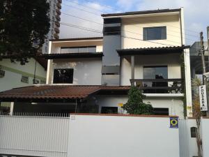 a white fence in front of a house at Pousada by Rieger in Blumenau