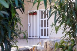 une porte blanche avec des plantes en pot sur elle dans l'établissement Apartment SunDelight, à Split