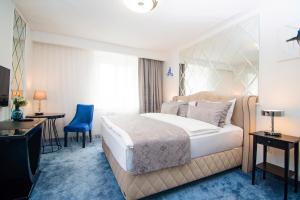 a hotel room with a bed and a desk and a television at 1st City Apartments in Vienna