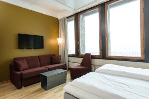 ein Hotelzimmer mit einem Bett und einem Sofa in der Unterkunft Quality Hotel 33 in Oslo