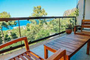 a wooden bench on a balcony with a view of the ocean at Addaura Mozzafiato in Mondello