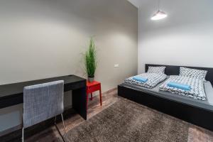 ブダペストにあるAnker Palace Apartmentのベッドとデスクが備わる小さな客室です。