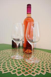 Dois copos de vinho ao lado de uma garrafa de vinho em Stylish Apartman Szeged em Szeged