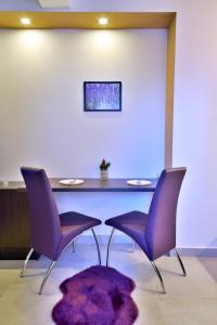 mesa de comedor con sillas moradas y alfombra púrpura en Apartments Vila Marina, en Zlatibor