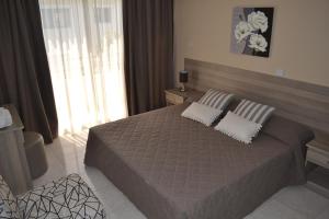 a bedroom with a large bed with two pillows at Marianna Hotel Apartments in Limassol