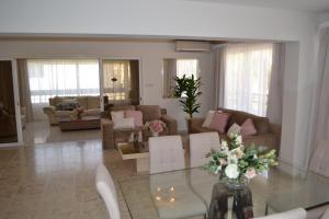 a living room with a glass table with flowers on it at Marianna Hotel Apartments in Limassol