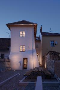 a white building with a bench in front of it at Stajnhaus in Mikulov