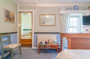 a bedroom with a bed and a chair and a table at Kilna BnB in Saltash