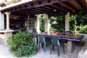 a wooden table and chairs under an outdoor patio at Luz del Mar - vis-à-vis Yachthafen in Denia