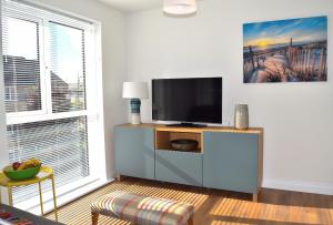 a living room with a flat screen tv on a cabinet at Westlake Apartments in Peterborough