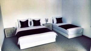 two beds in a room with black and white at Motel Aura in Mostar
