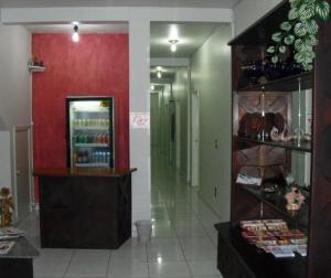 a store hallway with a red wall and a display case at Hotel São João in Campinas