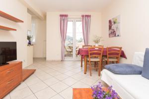 a living room with a couch and a table and chairs at Alpeza apartments in Bol