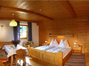ein Schlafzimmer mit einem großen Bett in einem Holzzimmer in der Unterkunft Hacklhof in Kössen