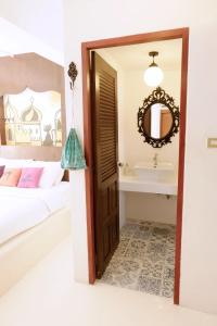 1 dormitorio con cama, espejo y lavamanos en Riad Hua Hin, en Hua Hin