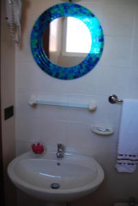 a bathroom with a sink and a mirror on the wall at Appartamenti Corneliani II in Sirmione +16 photos