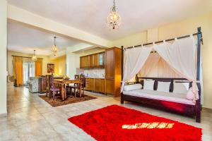 パリウリにあるAkritas Ef Zin Villas & Suitesのベッドルーム1室(ベッド1台、赤い敷物付きのテーブル付)