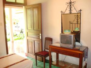 Habitación con escritorio, TV y espejo. en Hotel Casa Duranta, en Cobán