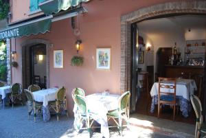 a restaurant with white tables and chairs and an open doorway at Appartamenti Corneliani II in Sirmione