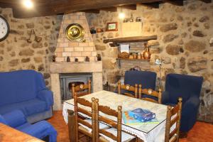 a living room with a table and chairs and a fireplace at Casa Rural La Pastera in Trevejo