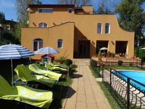 a house with a pool and some chairs and umbrellas at Vila Diamant in Neptun