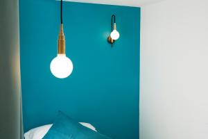 a room with two lights and a blue wall at Hotel Haussmann Saint Augustin in Paris