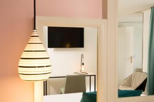 a room with a mirror and a table and a television at Hotel Haussmann Saint Augustin in Paris
