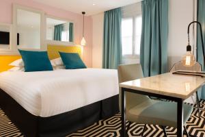 a hotel room with a bed and a desk at Hotel Haussmann Saint Augustin in Paris