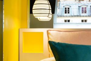 a room with a couch and a window and a light at Hotel Haussmann Saint Augustin in Paris