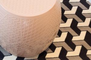 a white vase with a geometric pattern on the floor at Hotel Haussmann Saint Augustin in Paris