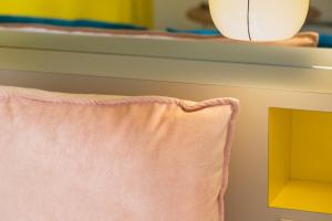 a pink pillow on a bed with a light at Hotel Haussmann Saint Augustin in Paris